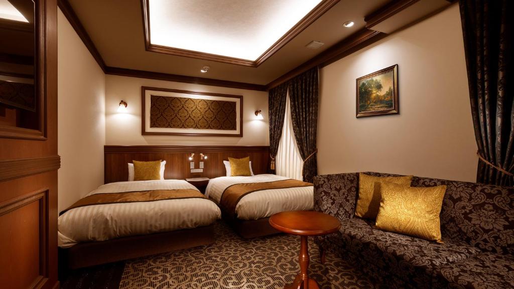Hiroshima Grand Intelligent Hotel في هيروشيما: غرفة فندقية بسريرين واريكة
