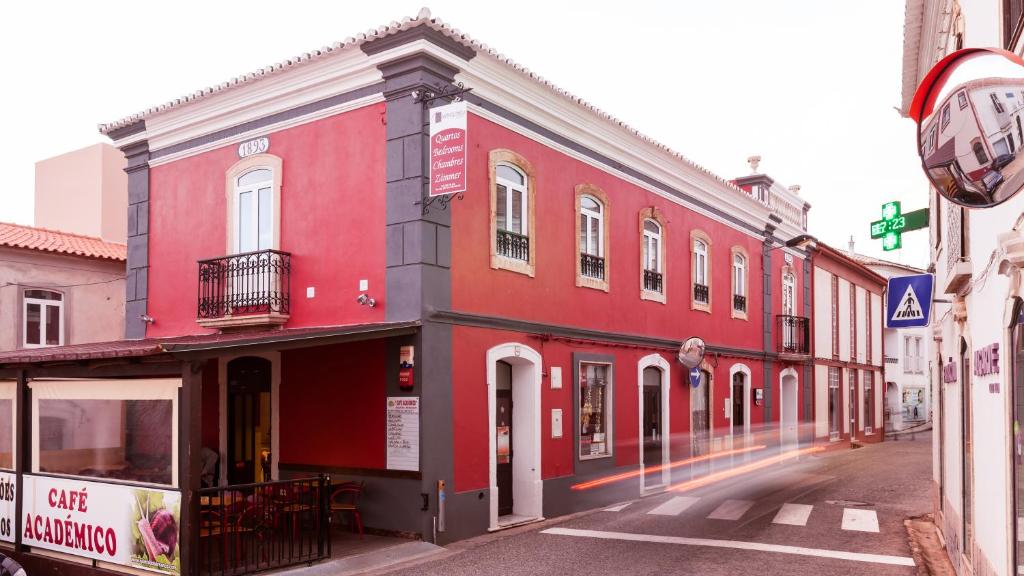 un edificio rojo al lado de una calle en Bartholomeu Guesthouse, en São Bartolomeu de Messines