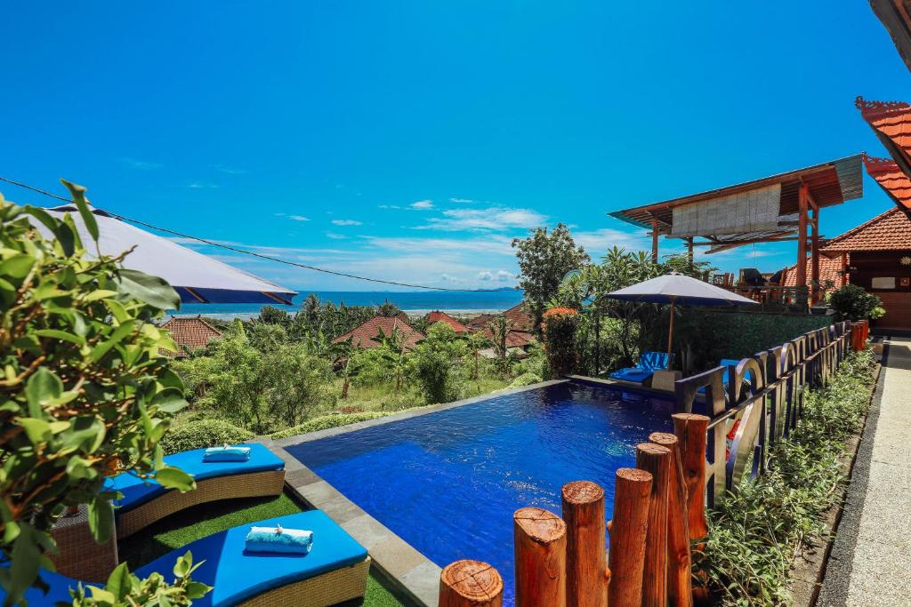 una piscina in un cortile con recinzione in legno di You and We House a Nusa Penida
