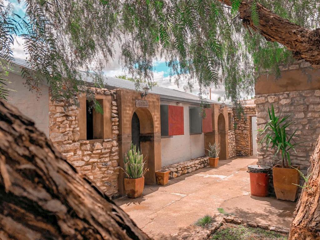 una casa de piedra con plantas delante de ella en Nkisi Guesthouse en Kang