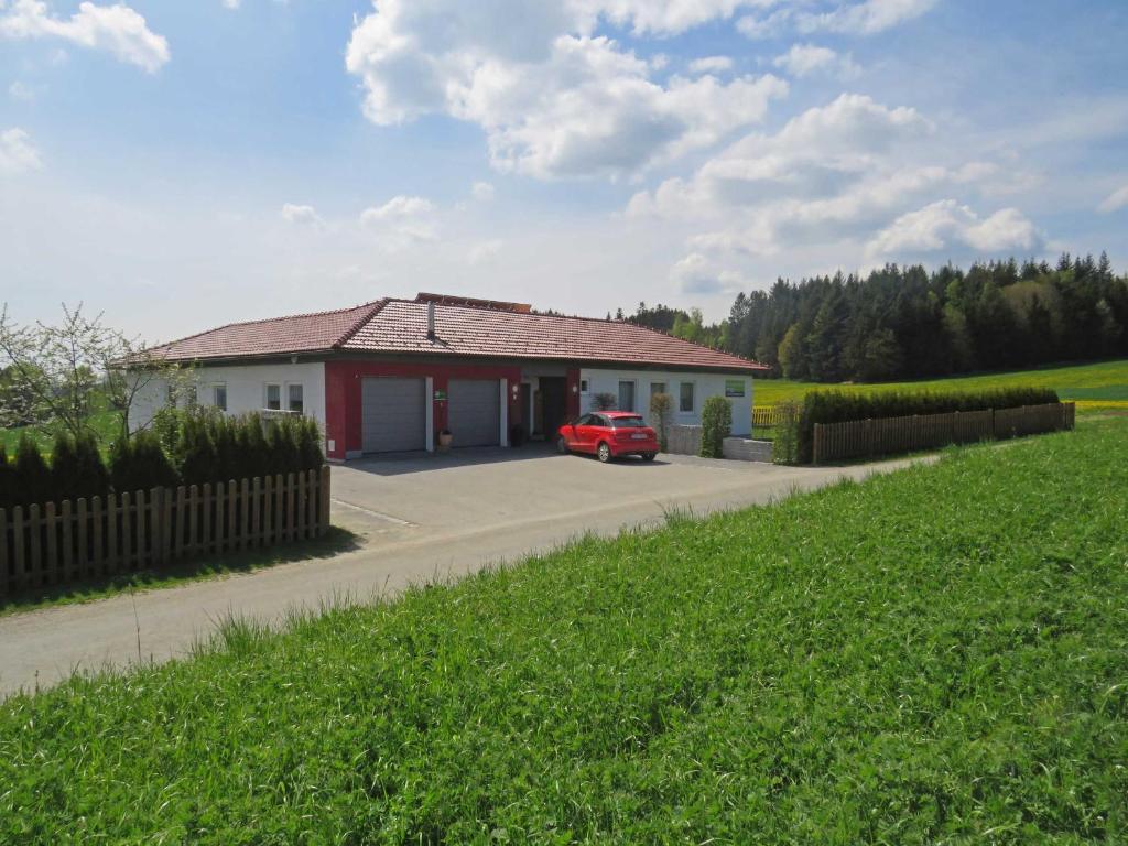 Wetzendorf的住宿－Traumferienhaus XXL Ortner，停在房子前面的红色汽车