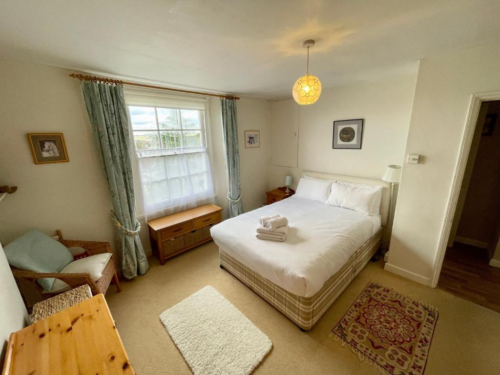 a bedroom with a bed and a chair and a window at Cosy boutique apartment in colourful Bristol in Bristol