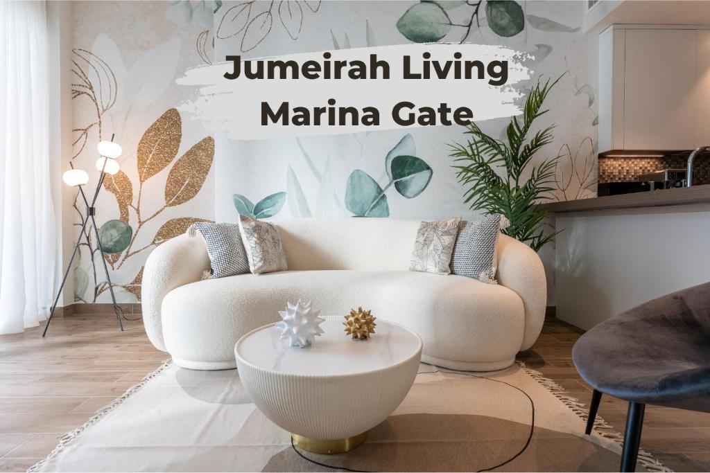 ein Wohnzimmer mit einem weißen Sofa und einem Tisch in der Unterkunft Desert Living Luxury Condo - Jumeirah Living Marina Gate in Dubai