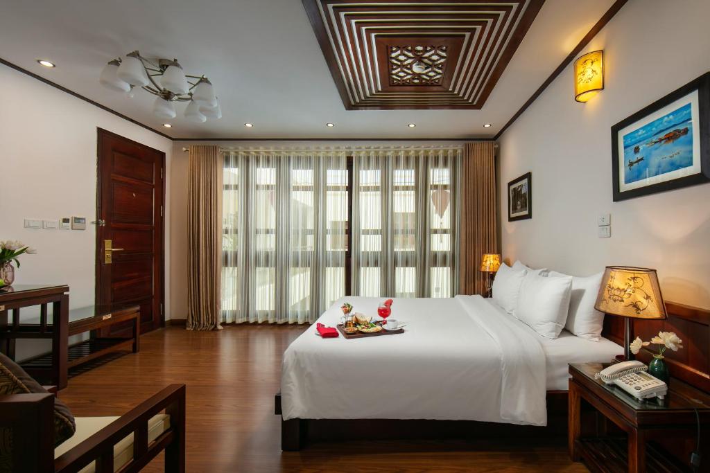 Postel nebo postele na pokoji v ubytování Hanoi Nostalgia Hotel & Spa