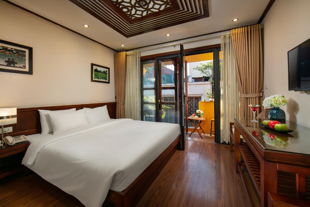 Postel nebo postele na pokoji v ubytování Hanoi Nostalgia Hotel & Spa