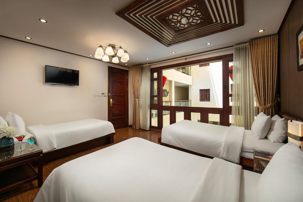Postel nebo postele na pokoji v ubytování Hanoi Nostalgia Hotel & Spa