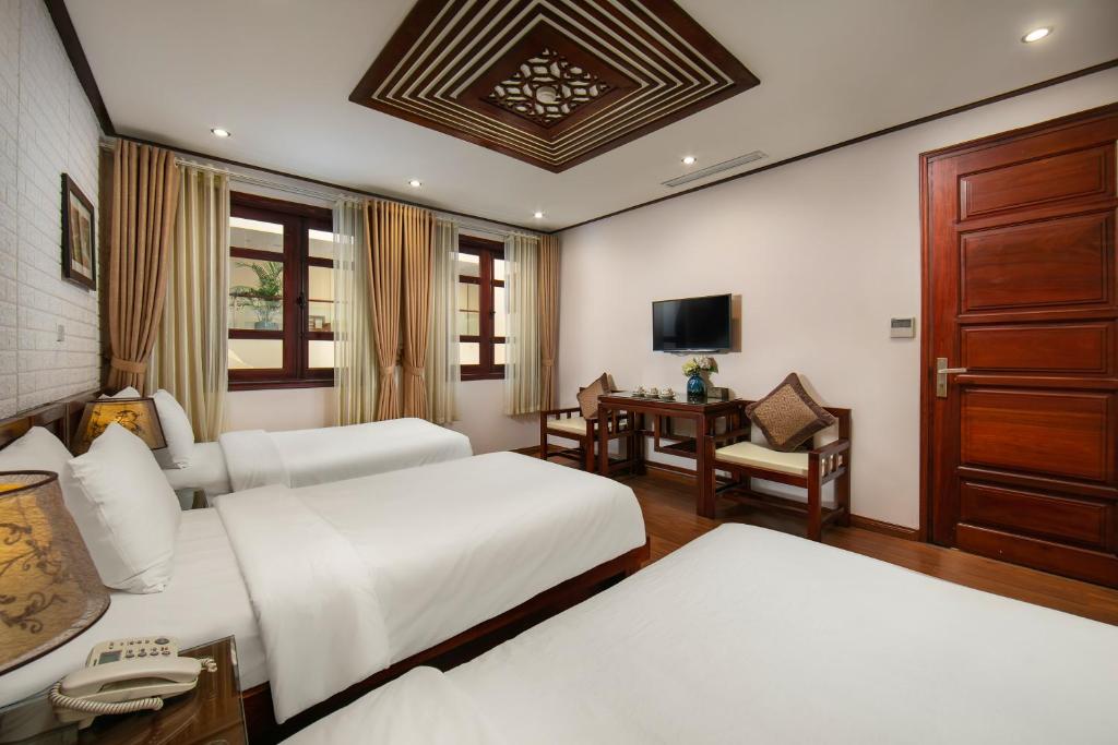 Postel nebo postele na pokoji v ubytování Hanoi Nostalgia Hotel & Spa