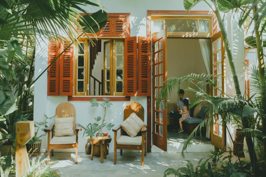Un uomo seduto in un soggiorno in una casa di The Wooden Gate a Xuân Sơn