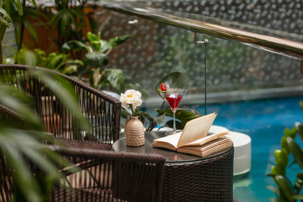 a table with a book and a glass of wine at Hanoi Nostalgia Hotel & Spa in Hanoi