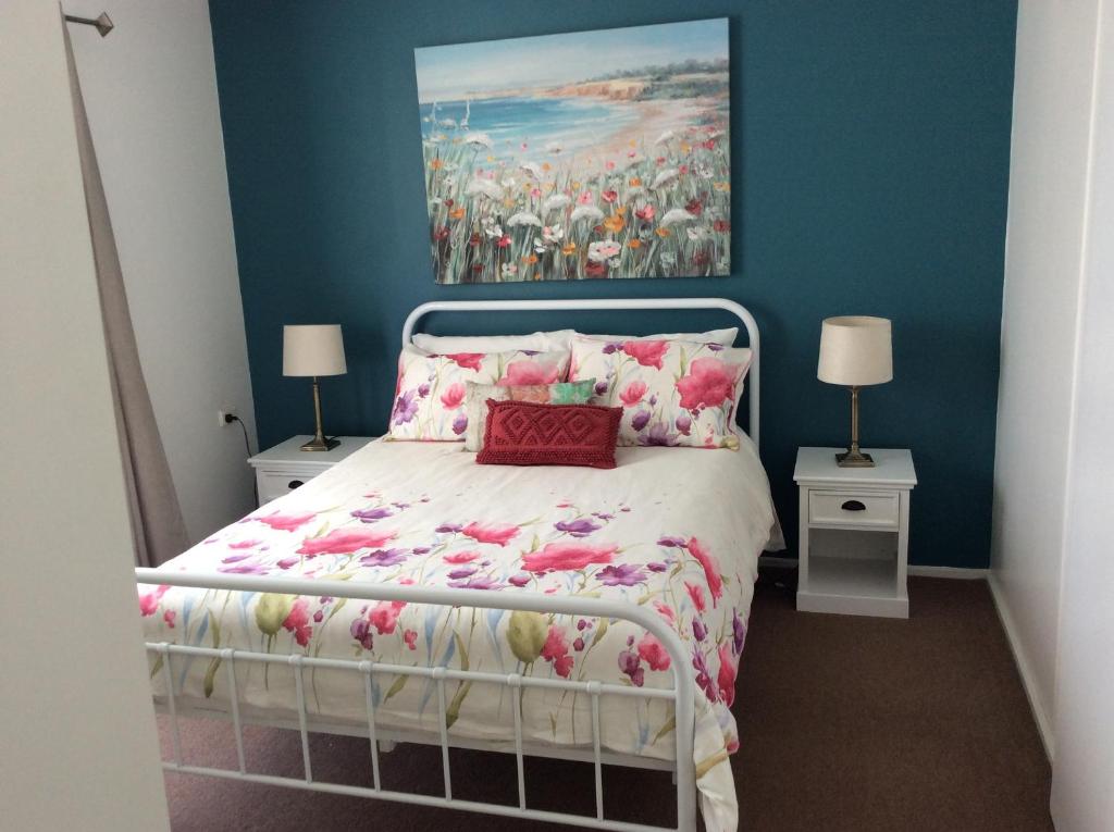 1 dormitorio con 1 cama con una pintura en la pared en Cozy Home Style Accommodation, en Marong