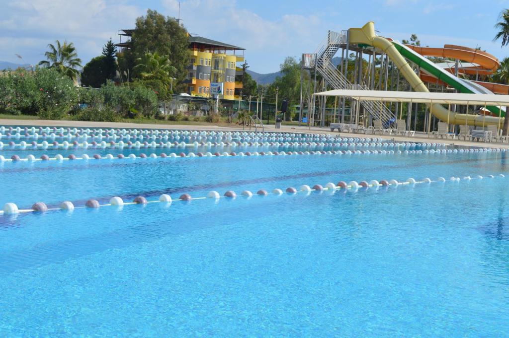 a large swimming pool with a water slide at Bülent Kocabaş-Selinus Beach Club Hotel in Gazipasa