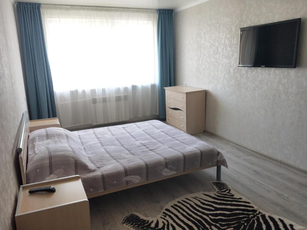a small bedroom with a bed and a window at Абая in Petropavlovsk