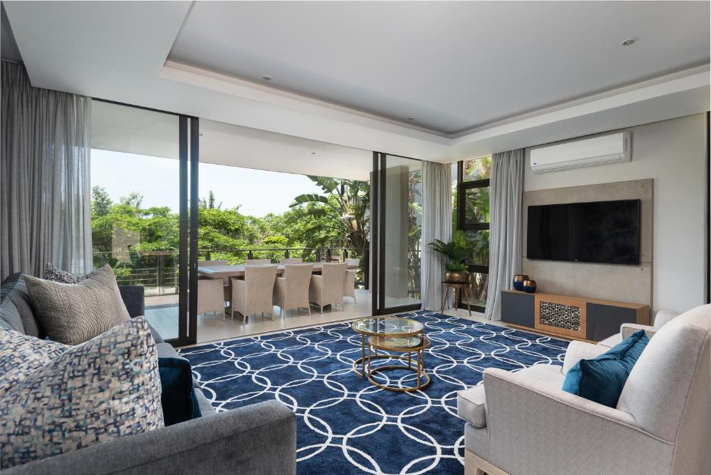 a living room with chairs and a television and a table at Luxury 3 Bed Villa- Zimbali Coastal Resort Retreat in Ballito