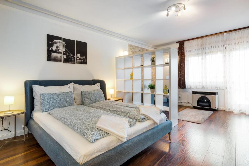 sypialnia z łóżkiem i niebieską kanapą w obiekcie dFive River View Apartment w Budapeszcie