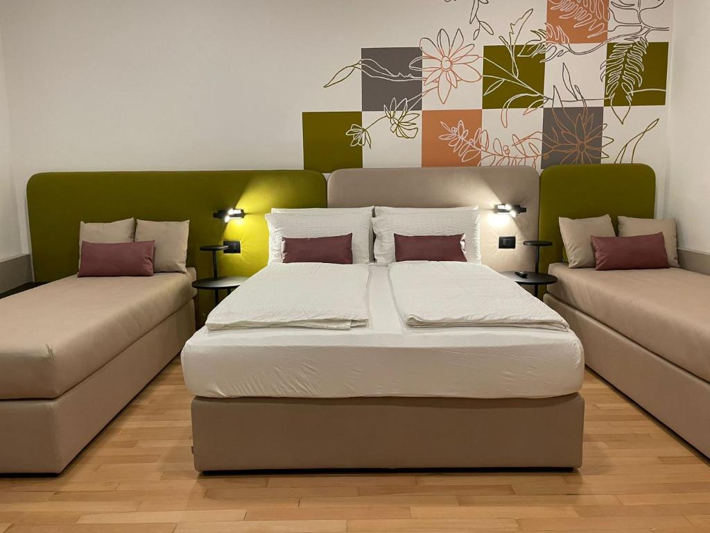 een slaapkamer met een bed en een bank bij House of Bruno Apartments - Only self check-in in Trento