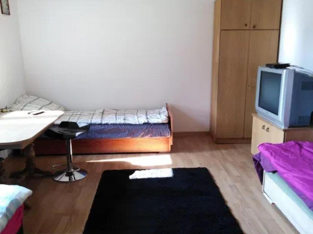 Habitación con cama, escritorio y TV. en noclegi kwatery, en Wola Rębkowska