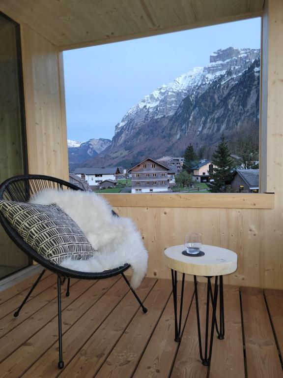 uma cadeira e uma mesa numa varanda com vista para a montanha em Haus im WALDner em Mellau