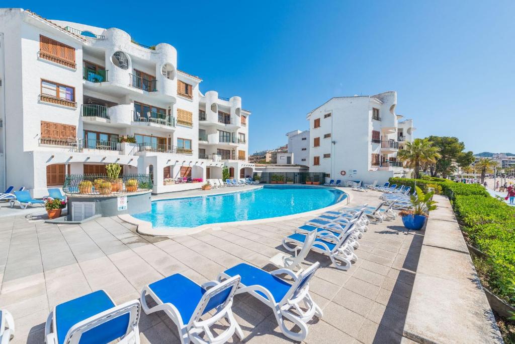 un hotel con piscina y tumbonas en Apartment Rovelló - Port d'Alcúdia en Puerto de Alcúdia