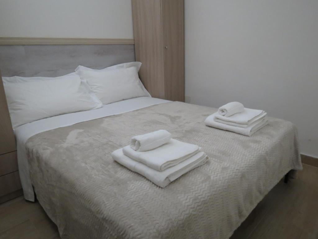 ein Bett mit drei Handtüchern darüber in der Unterkunft Suite 241 Catania in Catania