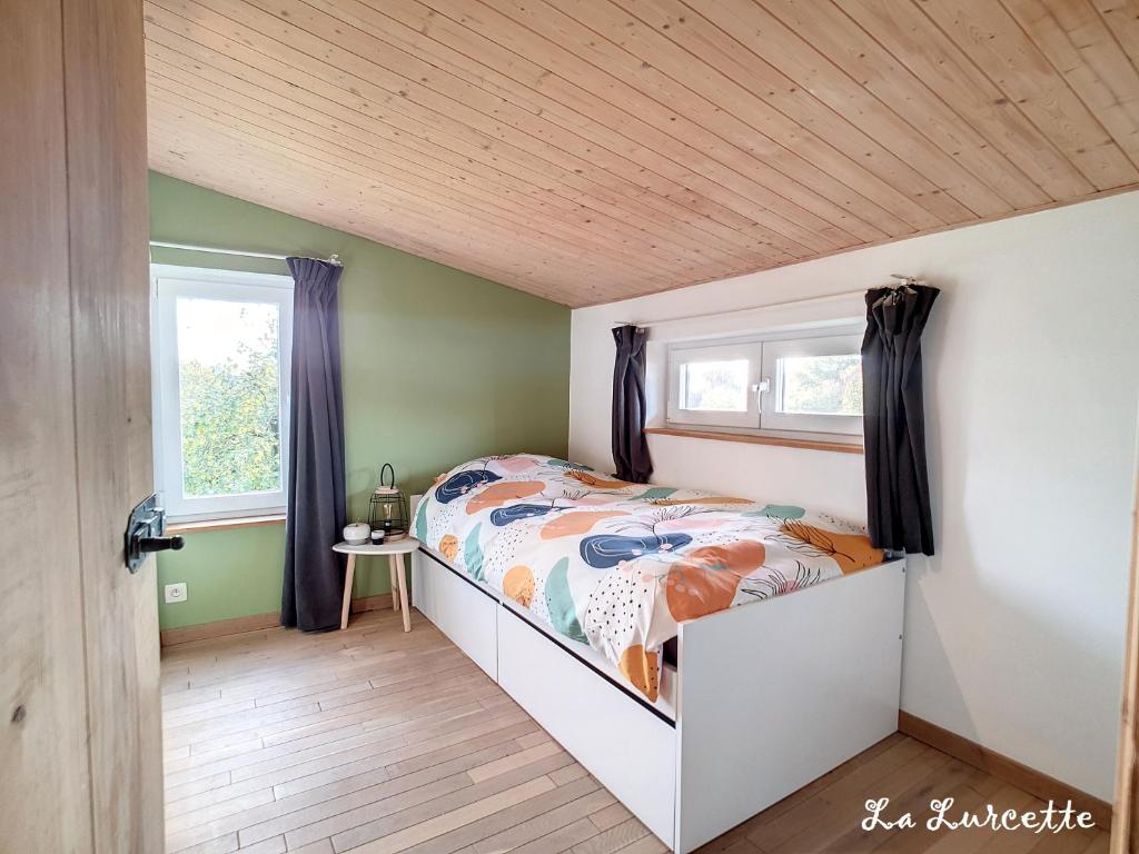 リバンにあるHoliday home le Lurçon et la Lurcetteのベッドルーム1室(ベッド1台、窓2つ付)