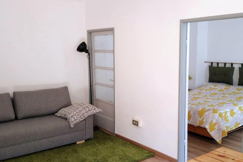 uma sala de estar com um sofá e uma cama em Bilocale nel cuore di Genova em Gênova