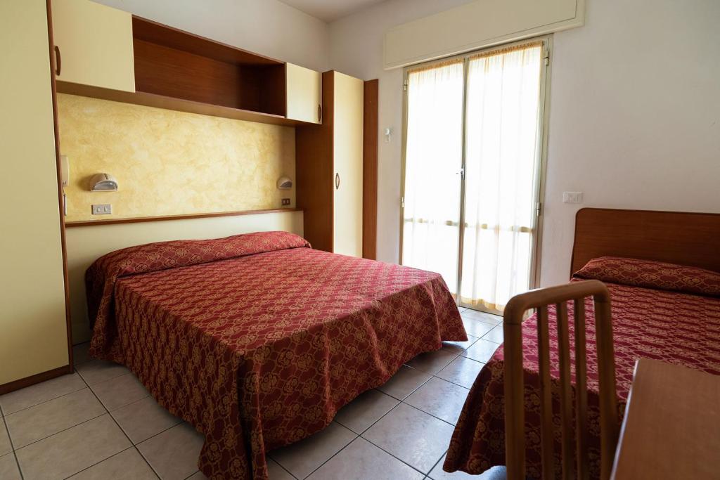 a hotel room with a bed and a window at Hotel Zanella in Cervia