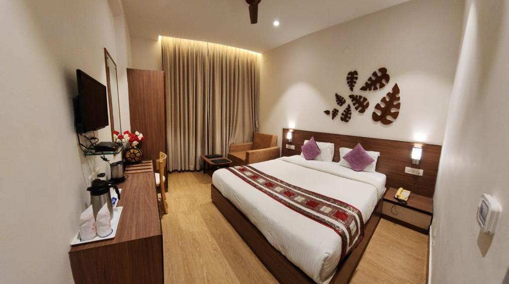 Hotel Gorbandh في أودايبور: غرفة فندقية بسرير كبير وغرفة بقلوب على الحائط