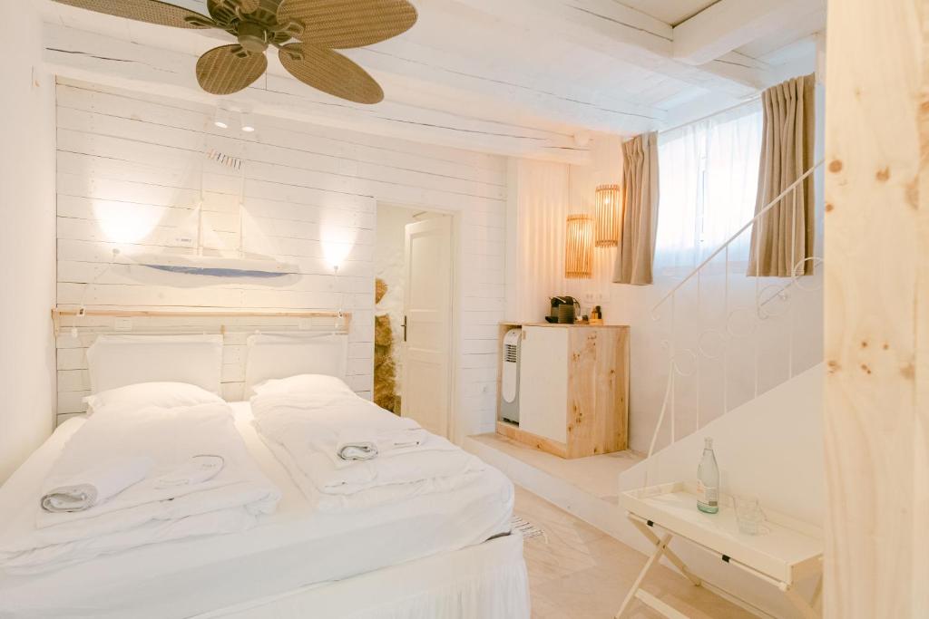 een witte slaapkamer met een bed en een koelkast bij Romantic Stone House Double room in Kornić