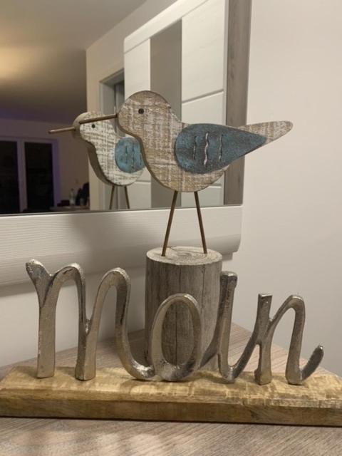 a wooden bird sitting on top of a wooden sign at Schillig, Nordsee - Friesland - Wohnung - neu in Wangerland