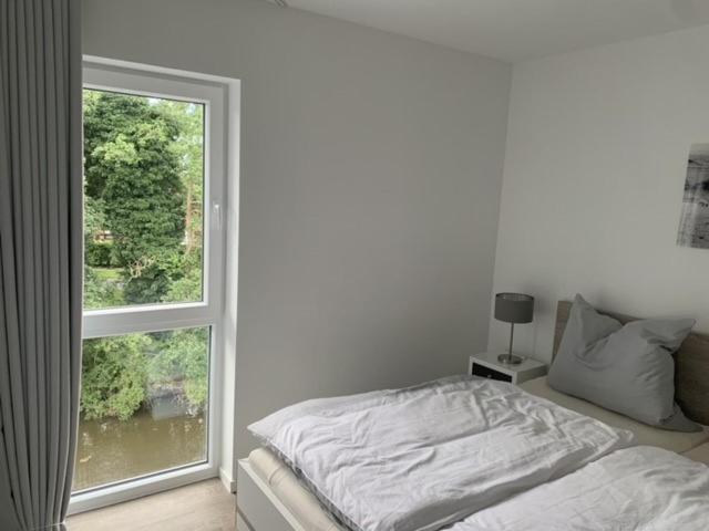 1 dormitorio con cama y ventana grande en Schillig, Nordsee - Friesland - Wohnung - neu en Wangerland