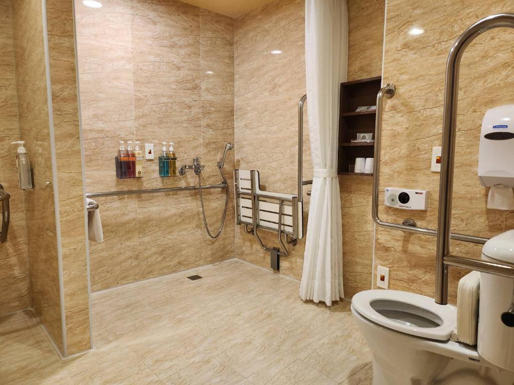 a bathroom with a shower and a toilet at Kindness Hotel - Kaohsiung Main Station in Kaohsiung