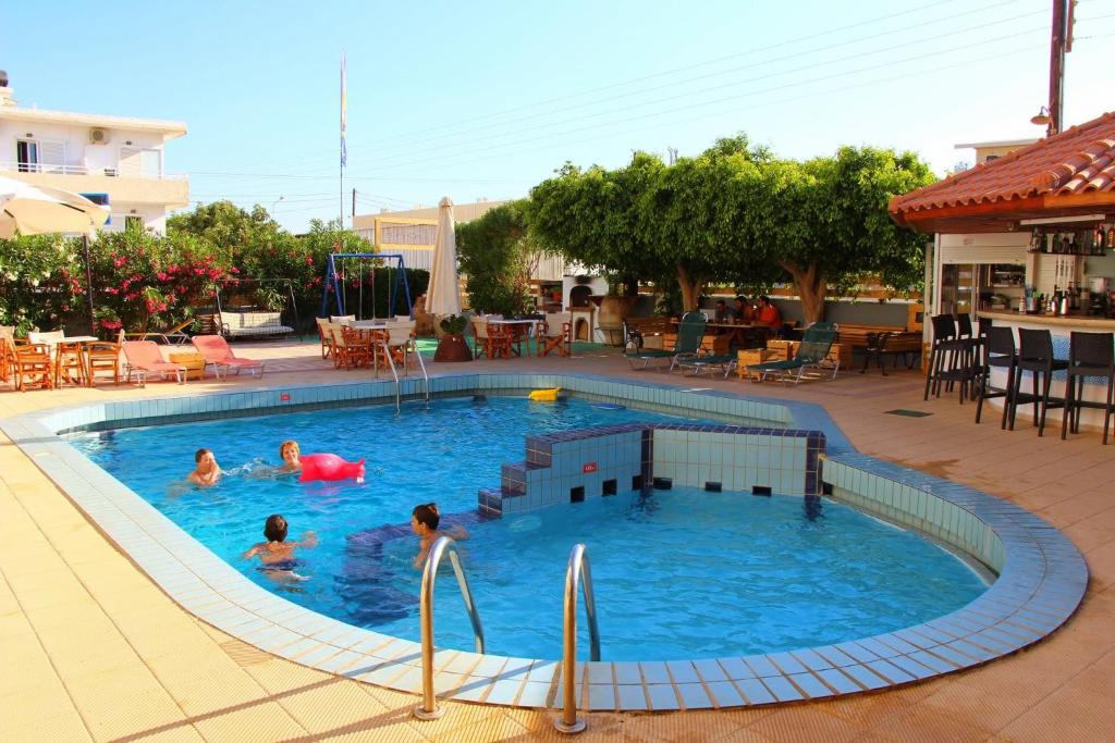a group of people swimming in a swimming pool at Albatross Apartments in Amoudara Herakliou