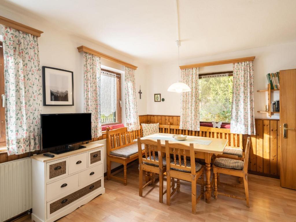a dining room with a table and a television at Holiday Home Richter by Interhome in Zistl