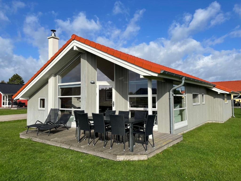 a house with a table and chairs on a deck at Holiday Home Holiday Vital Resort - GBE111 by Interhome in Großenbrode