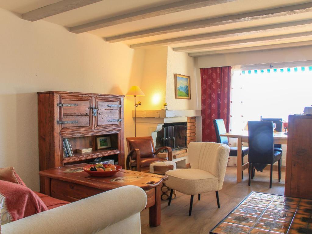 een woonkamer met een bank, een tafel en stoelen bij Apartment Les Girolles B15 by Interhome in Villars-sur-Ollon