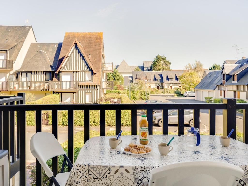 a table with a plate of food on a balcony at Apartment Fleur Marine-9 by Interhome in Cabourg