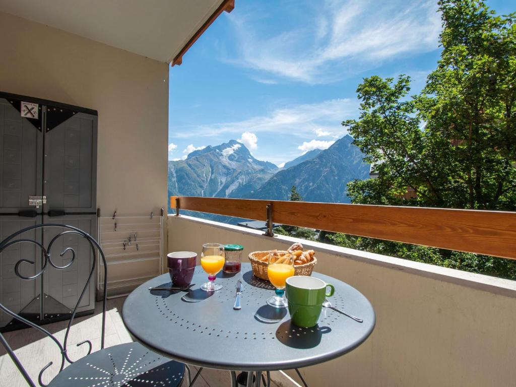 uma mesa na varanda com 2 copos de sumo de laranja em Apartment Chalets du Soleil-21 by Interhome em Les Deux Alpes