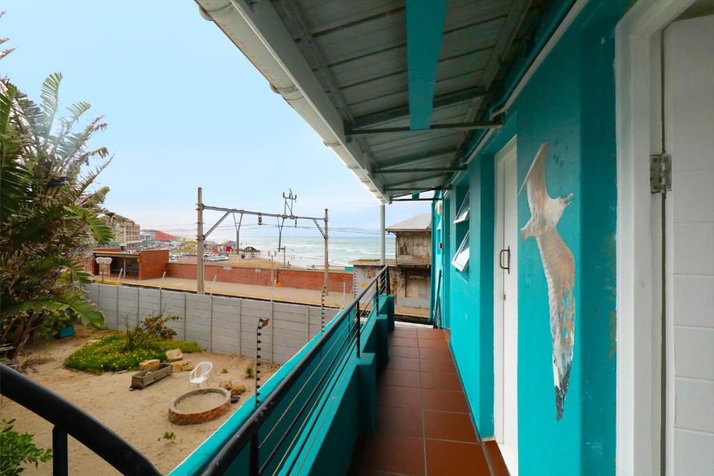 a balcony of a house with a view of the ocean at Stoked Backpacker Apartments in Muizenberg