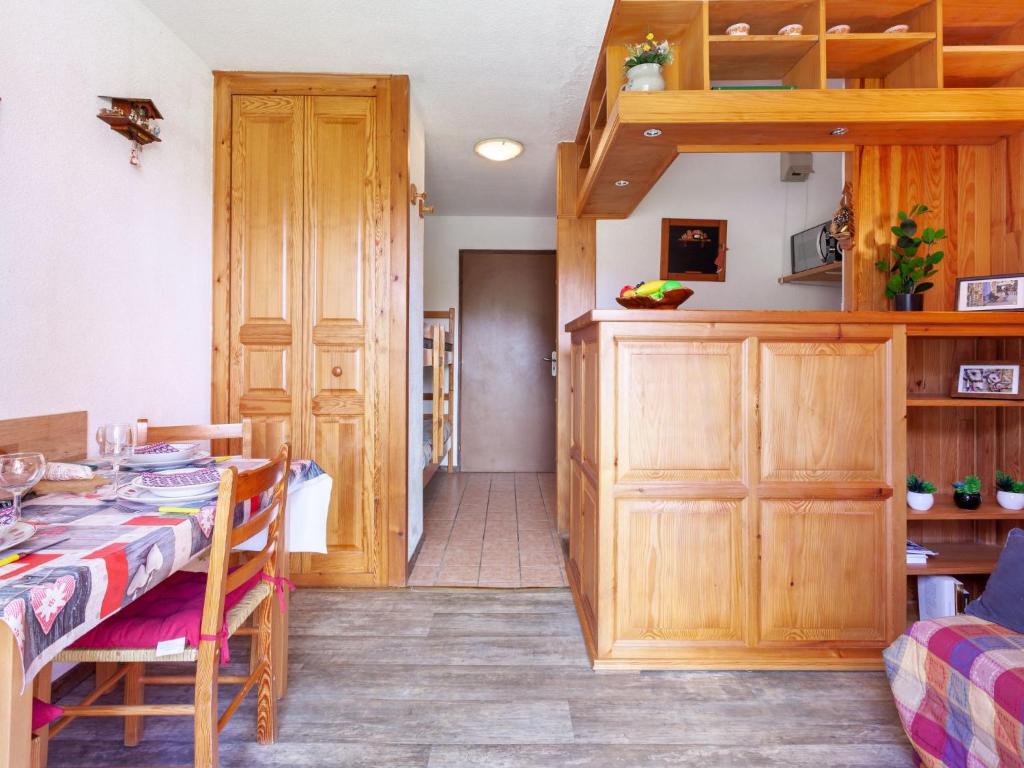 - une cuisine et une salle à manger avec une table et des placards en bois dans l'établissement Apartment Le Bochate-4, à Saint-Pancrace