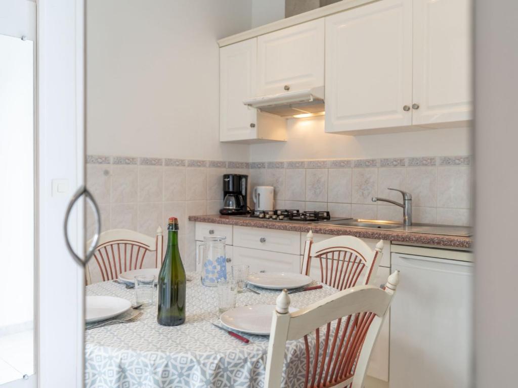 a kitchen with a table with a bottle of wine at Apartment Le Chalet by Interhome in Cabourg