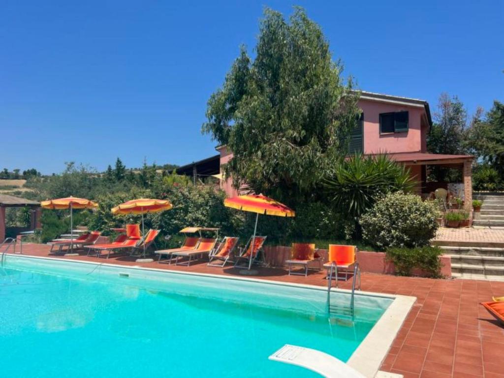 een zwembad met stoelen en parasols bij Apartment Contrada Brecciano-1 by Interhome in Città Sant'Angelo