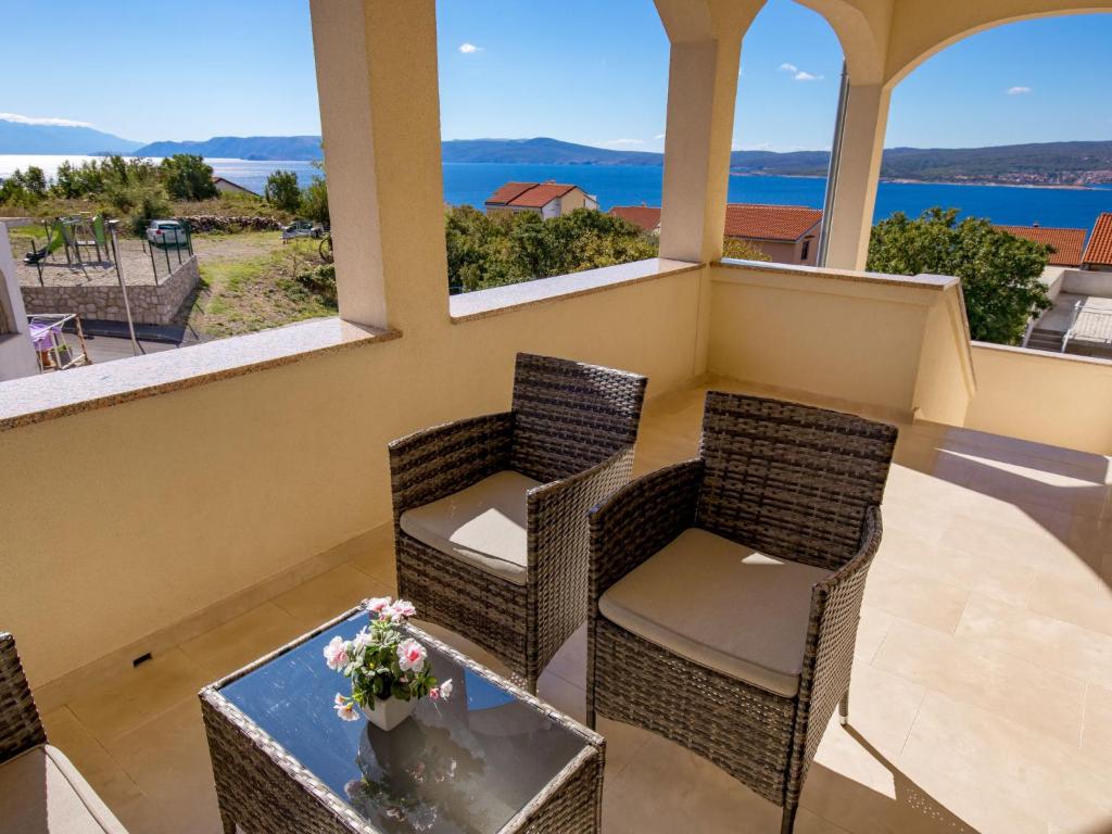 a balcony with chairs and a table with a view of the ocean at Apartment Nikol - CKV123 by Interhome in Crikvenica