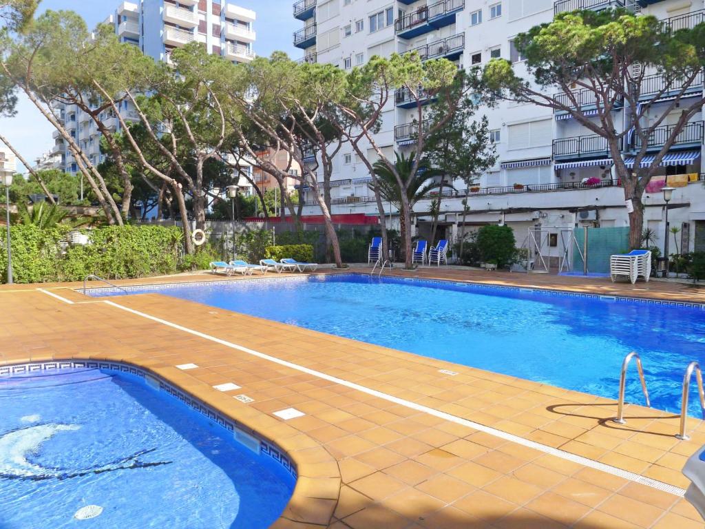 a swimming pool in a city with trees and buildings at Apartment Santa Cruz by Interhome in Blanes