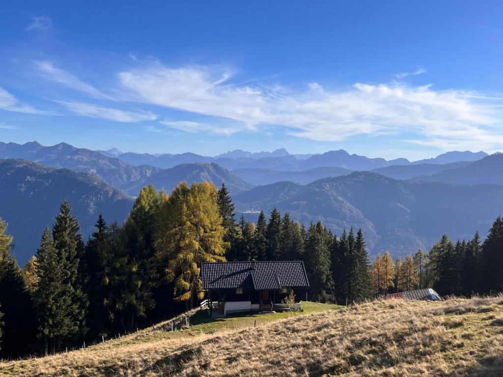 a house on a hill with mountains in the background at Chalet Wassertheureralm by Interhome in Greifenburg