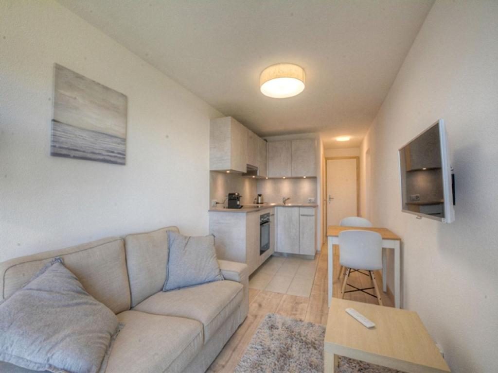 een woonkamer met een bank en een keuken bij Apartment Topaze-2 by Interhome in Anzère