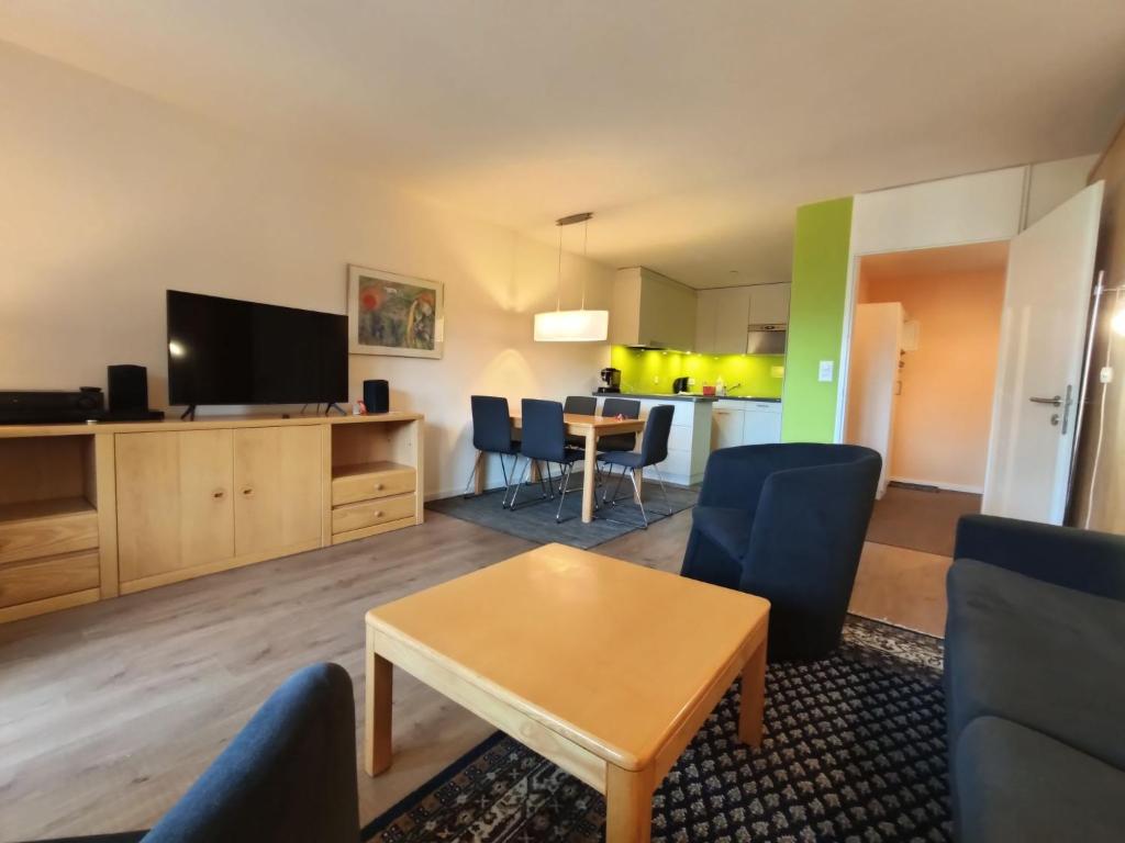 - un salon avec une table et une télévision dans l'établissement Apartment Allod-Park-28 by Interhome, à Davos