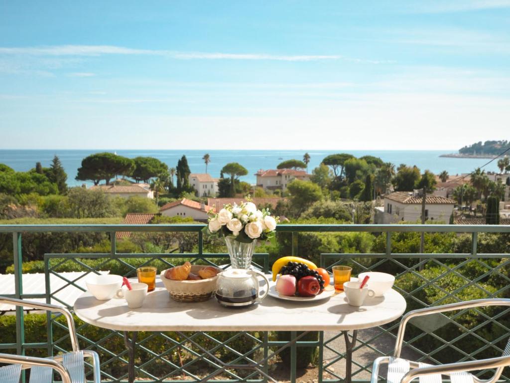 - une table avec un bol de fruits et de fleurs sur le balcon dans l'établissement Apartment Riva Bella-2 by Interhome, à Cavalaire-sur-Mer