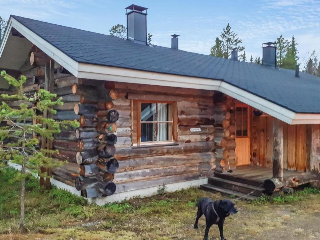 einem Hund, der vor einem Blockhaus steht in der Unterkunft Holiday Home Tähtiruka 3 by Interhome in Ruka