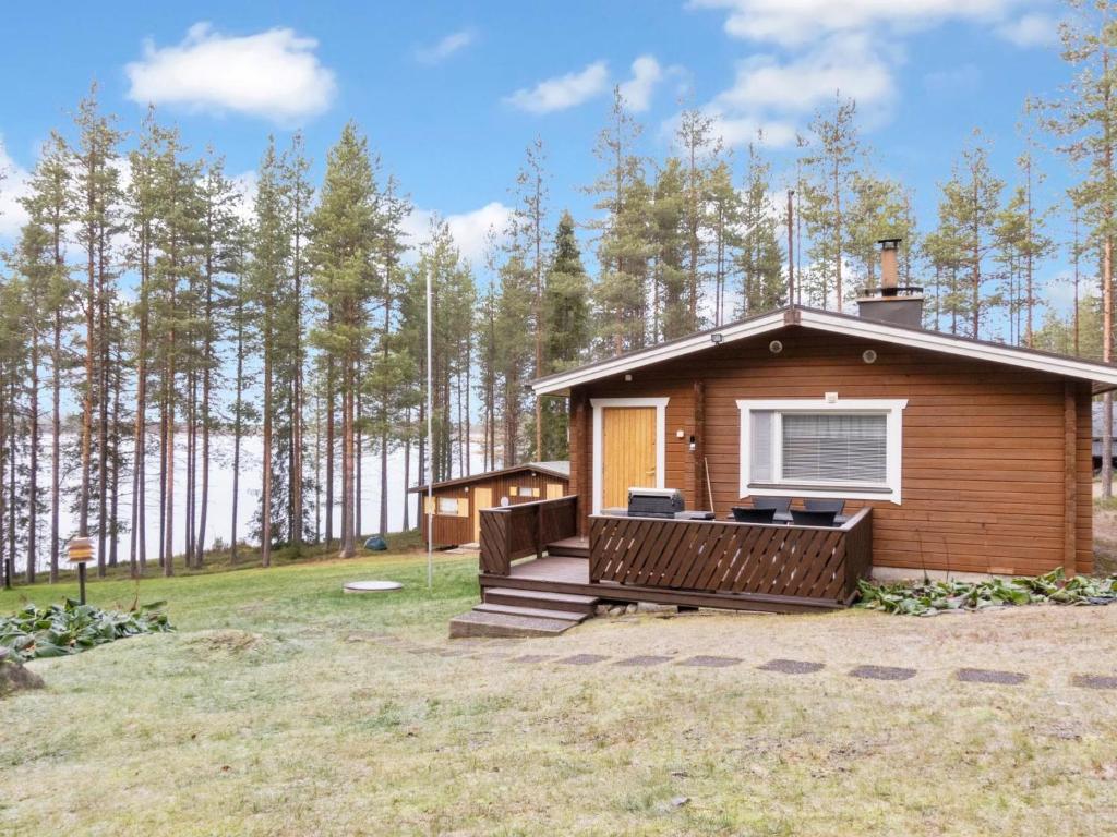 a small cabin with a deck in a yard at Holiday Home Järvelä by Interhome in Kemijärvi