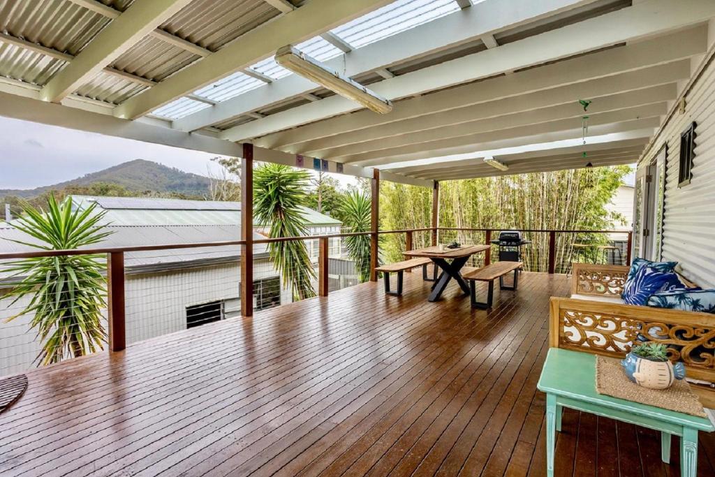 an open deck with a table and chairs on a balcony at Sunset Haven in Shoalhaven Heads